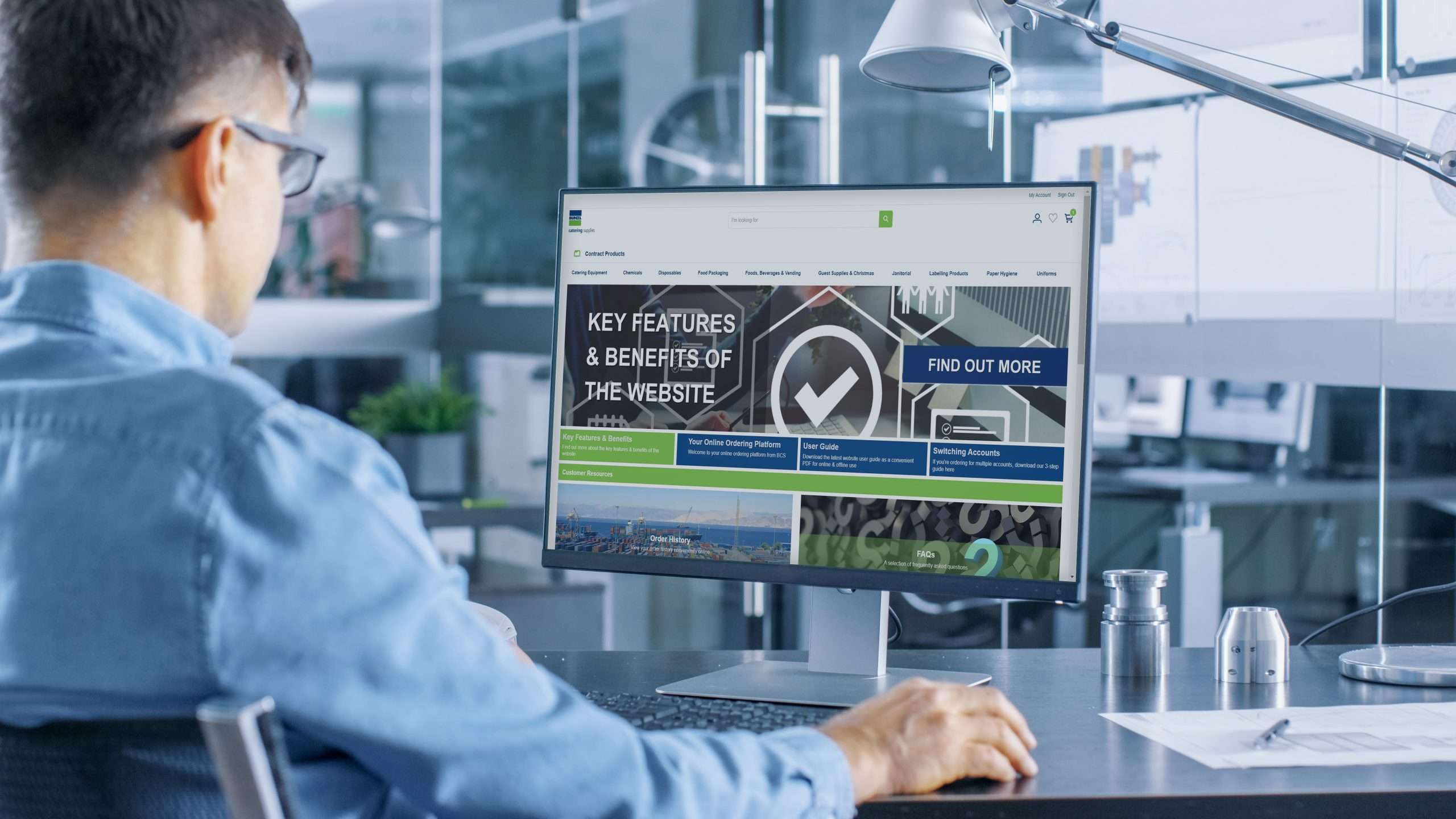 Automotive Engineer Working on a Personal Computer With Isolated Mock-up Green Screen on it. He Works in the Bright and Modern Office with Car Sketches on the Walls.
